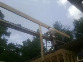 Carpenter setting a ridge beam over a new addition frame — Ice Dam Removal by Roofing Brothers in Kahului